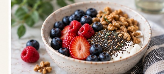 A bowl of yogurt topped with berries, walnuts, and chia seeds